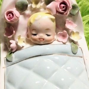 Vintage blonde baby sleeping piggy bank.